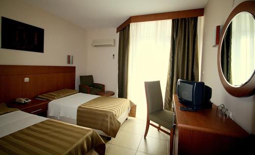 a hotel room with two beds and a tv at Surtel Hotel in Kusadası