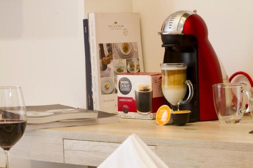 a table with a coffee maker and a glass of wine at De Película Hotel in Bogotá