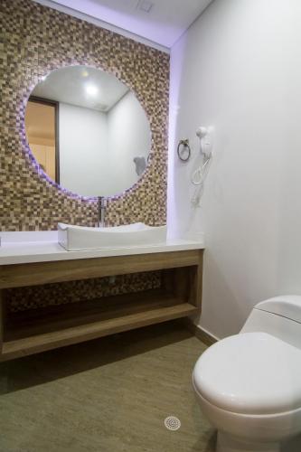 a bathroom with a white toilet and a mirror at De Película Hotel in Bogotá