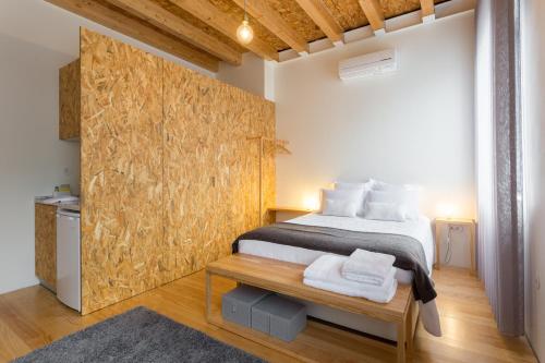 a bedroom with a bed and a wooden wall at Casa da Figueiroa in Porto
