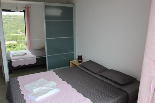 a bedroom with a bed and a large window at Villa Santa in Porto-Vecchio