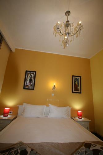 a bedroom with a large bed and a chandelier at Hotel-Hostel Mignon Mamaia -private rooms with free parking in Mamaia