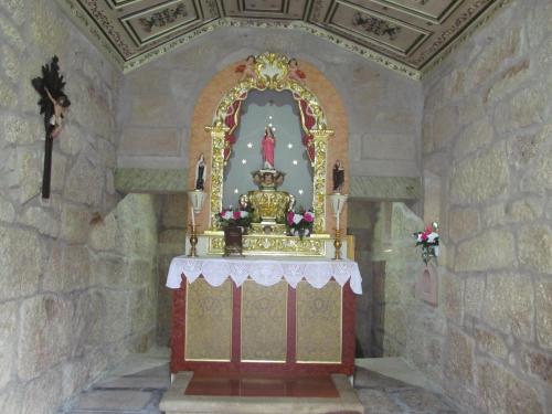 a small altar in a room with a stone wall at Hotel Solar da Capela in Termas de Sao Pedro do Sul