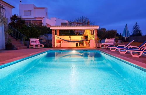 a swimming pool with chairs and a swing in a house at Villa Solarium in Carvoeiro