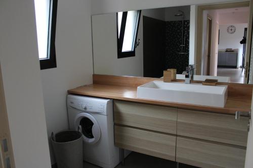 a bathroom with a sink and a washing machine at Villa Santa in Porto-Vecchio