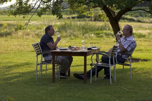 two men sitting at a table with glasses of wine at Landhuis Hotel Rikus in Eext