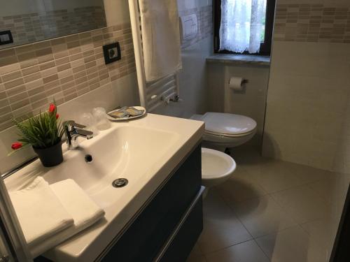 ein Badezimmer mit einem weißen Waschbecken und einem WC in der Unterkunft 85Centro in Potenza