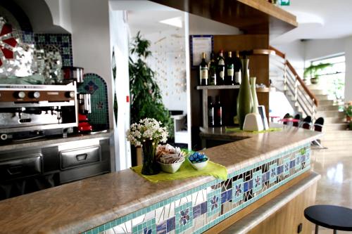 een keuken met een aanrecht met bloemen en wijnflessen bij Hotel Capri in Bellaria-Igea Marina