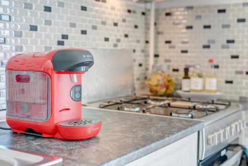 a red toaster sitting on top of a kitchen counter at Bucharest Airport Suites & Villas in Otopeni
