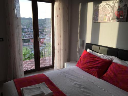 Schlafzimmer mit einem Bett mit einem roten Kissen und einem Fenster in der Unterkunft 85Centro in Potenza