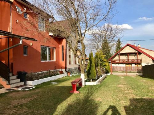 a red house with a red fire hydrant in the yard at Pensiunea Claudia in Beliş