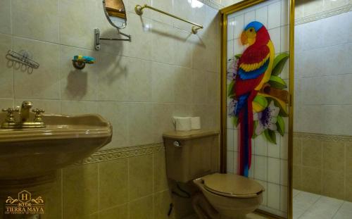 La salle de bains est pourvue d'un perroquet coloré sur le mur. dans l'établissement Hotel Tierra Maya, à San Cristóbal de Las Casas