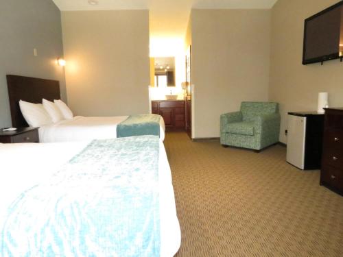 a hotel room with a bed and a chair at Edgewater Hotel and Suites in Put-in-Bay