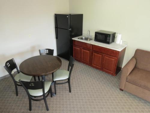 a kitchen with a table and a refrigerator and a couch at Edgewater Hotel and Suites in Put-in-Bay