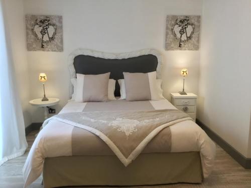 una camera da letto con un grande letto con due tavoli e due lampade di Casa 28 a Canosa di Puglia