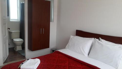 1 dormitorio con cama con almohadas blancas y aseo en Hotel Fontanar Corferias, en Bogotá