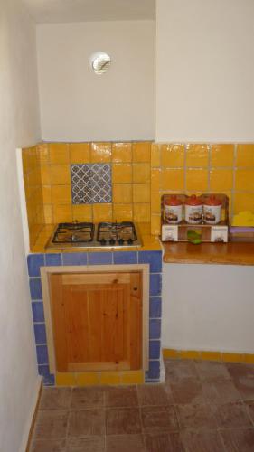 a kitchen with a blue and yellow tiled counter top at La Casa del Pescatore in Filicudi