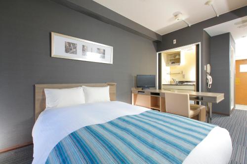 a hotel room with a bed and a desk at HOTEL MYSTAYS Otemae in Osaka