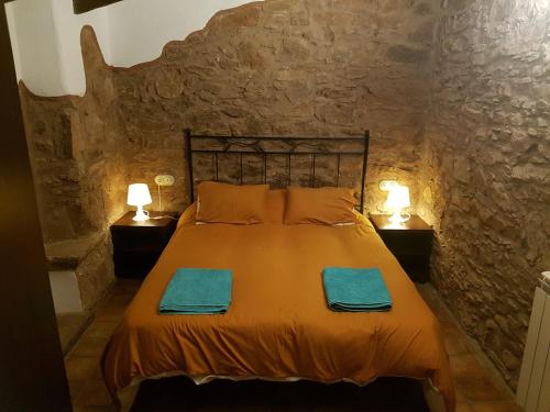 um quarto com uma cama numa parede de pedra em Les Casetes del Congost Vilatge Resort Barcelona em Tagamanent