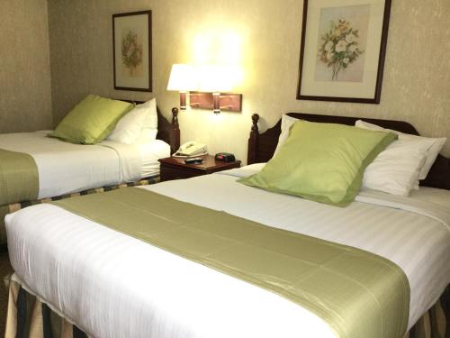 a hotel room with two beds and a phone at Americas Best Value Inn and Suites Saint Charles in St. Charles
