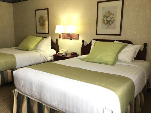 a hotel room with two beds and a phone at Americas Best Value Inn and Suites Saint Charles in St. Charles