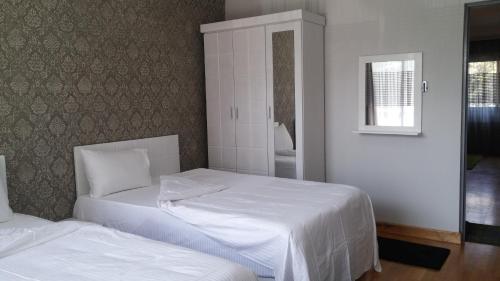 a bedroom with two beds with white sheets and a window at Khayatz Apartment in Cairo