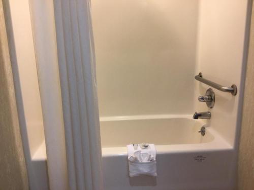 a bathroom with a bath tub with a towel in it at Americas Best Value Inn and Suites Saint Charles in St. Charles