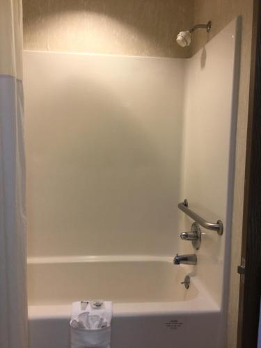 a bathroom with a bath tub with a towel at Americas Best Value Inn and Suites Saint Charles in St. Charles