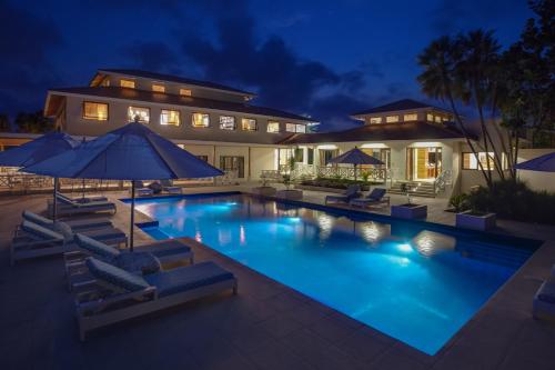 a house with a swimming pool at night at Naïa Resort and Spa in Placencia Village