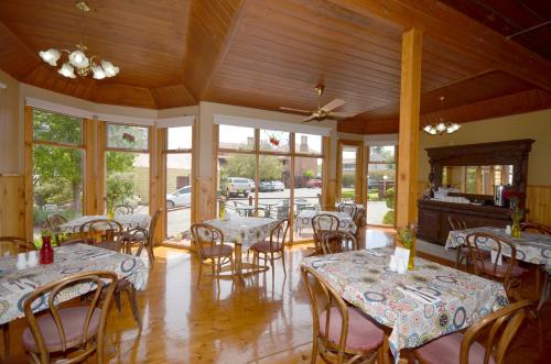 a dining room with tables and chairs and windows at Central Springs Inn in Daylesford