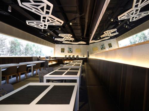 a dining room with white tables and chairs at Airline Inn Green Park Way in Taichung