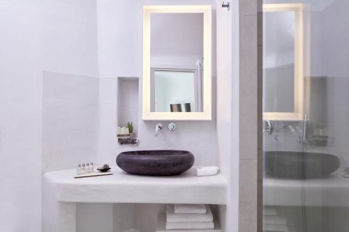 a bathroom with a sink and a mirror at Cosmopolitan Suites - Small Luxury Hotels of the World in Fira