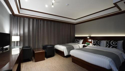 a hotel room with two beds and a television at Insadong Crown Hotel in Seoul