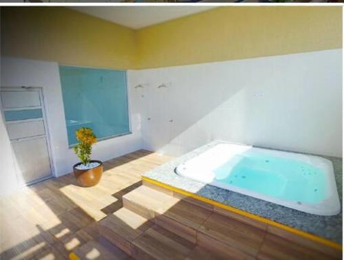 bañera grande en una habitación con maceta en Apartamento no Encontro das Águas, en Caldas Novas