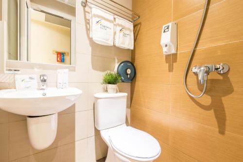 a bathroom with a toilet and a sink at Fragrance Hotel - Ocean View in Singapore