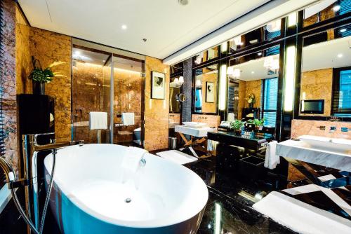 a bathroom with a large tub and a sink at Tylfull Hotel in Beijing