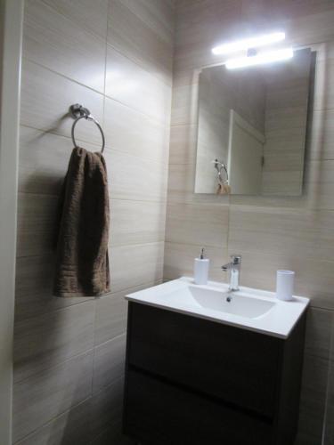 a bathroom with a sink and a mirror at Central Studio Apartment in Santa Venera
