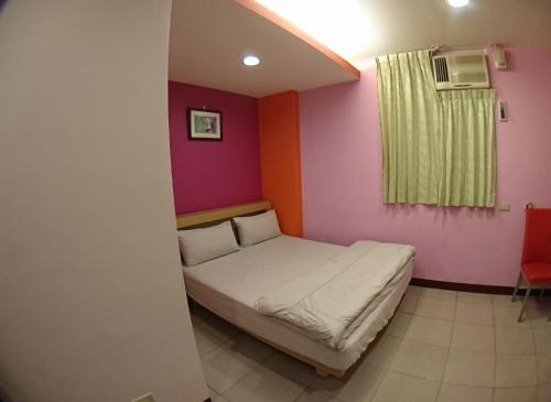 a small room with a bed in the corner at ZaiXiang in Tamsui