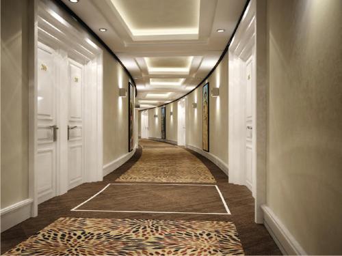 a hallway with a long corridor with white doors and a rug at Amanora The Fern Hotels & Club in Pune