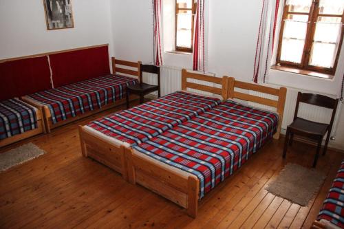 a bedroom with two beds and two chairs at A cigándi bíró háza in Cigánd