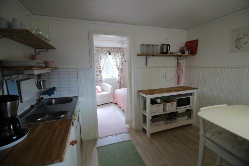 a kitchen with a sink and a room with a couch at Lövås Gård Koppera in Charlottenberg