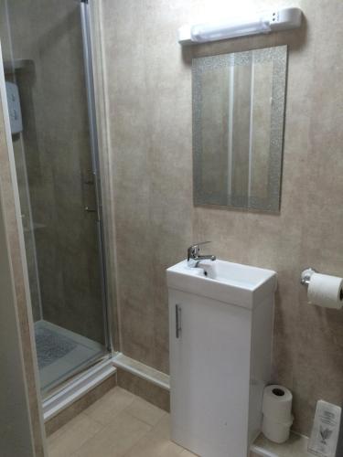 a bathroom with a shower and a toilet and a sink at The Oxfordshire in Blackpool