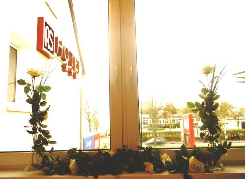 a window with a bunch of flowers on a window sill at AS Hotel in Göttingen