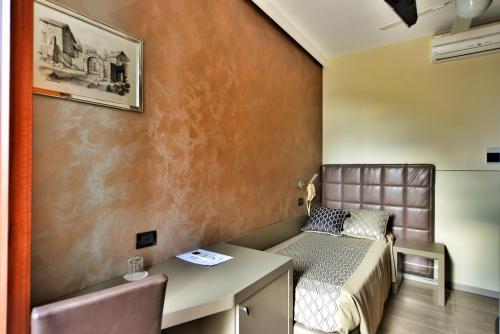 a small room with a bed and a desk at Hotel Sorriso in Toscolano Maderno