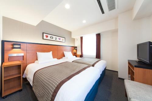 A bed or beds in a room at HOTEL MYSTAYS Sakaisuji Honmachi