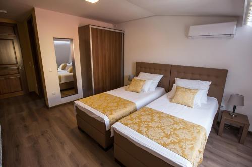 a hotel room with two beds and a mirror at Heartland City B&B in Tuzla