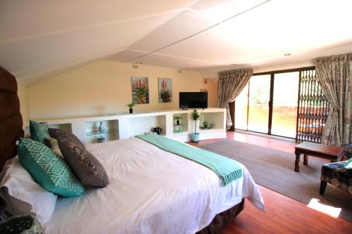 a bedroom with a large bed and a living room at House on Morninghill in Johannesburg