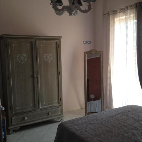 a bedroom with a dresser and a mirror at INFORMIS B&B in Capua