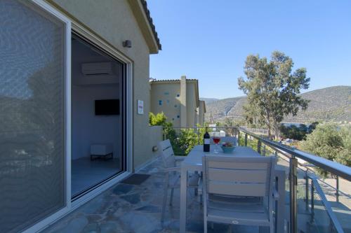 a patio with a table and chairs on a balcony at Lavender Cove in Korfos