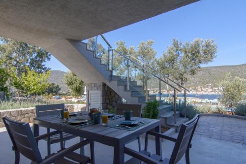 einen Tisch und Stühle auf einer Terrasse mit Treppen in der Unterkunft Lavender Cove in Korfos